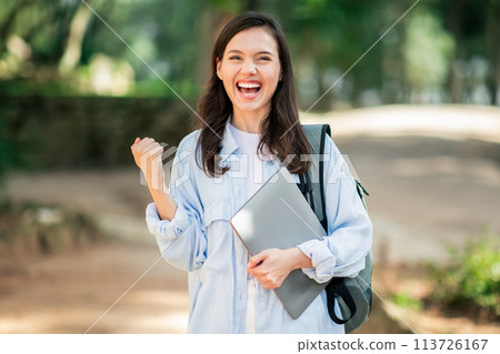 Enthusiastic young woman celebrating success with a fist pump Enthusiastic young woman celebrating success with a fist pump 113726167
