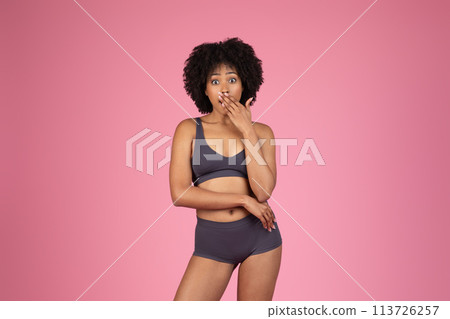 Surprised woman in sportswear covering mouth 113726257