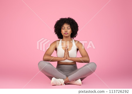 Meditating lady in peaceful yoga pose on pink background 113726292