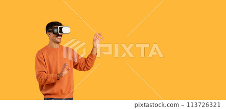 Guy engaging with virtual reality, wearing a VR headset Guy engaging with virtual reality, wearing a VR headset 113726321
