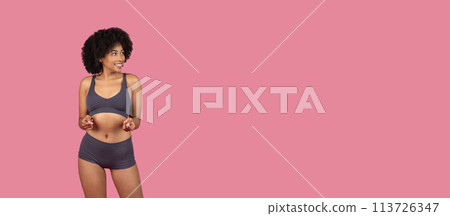 Engaging woman in sportswear with playful stance 113726347