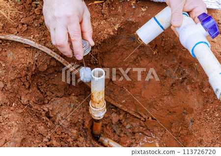 Before gluing pipes together, technician plumbers use clear primer for PVC pipe 113726720