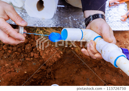Before adhering pvc plastic pipe, plumber seals it with glue Before adhering pvc plastic pipe, plumber seals it with glue 113726730