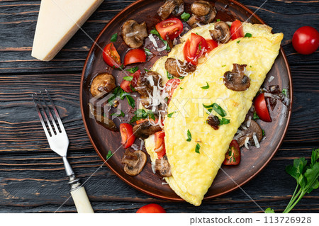 Omelette stuffed with mushrooms , tomatoes and parsley 113726928