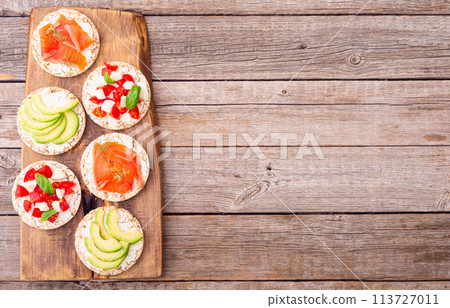 Crispbread with  salmon avocado mozzarella  and tomatoes 113727011