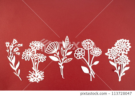 Carve of white paper leaves with empty space on a red cardboard. Carve of white paper leaves with empty space on a red cardboard. 113728047