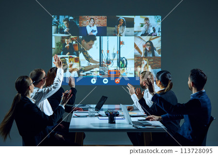 Workers in boardroom use video conferencing technology to connect with remote colleagues and facilitate collaboration. 3D printer project discussion 113728095