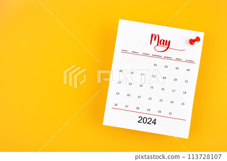 May 2024 calendar page with red push pin on yellow background. 113728107