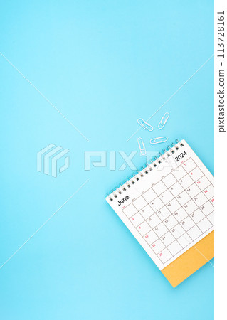 Desk calendar for June 2024 and white paper clip on a light blue background 113728161