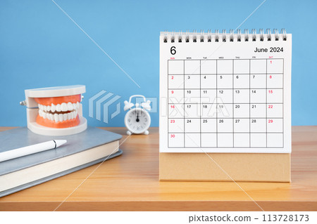 June monthly desk calendar for 2024 year and model dentures on the table. June monthly desk calendar for 2024 year and model dentures on the table. 113728173
