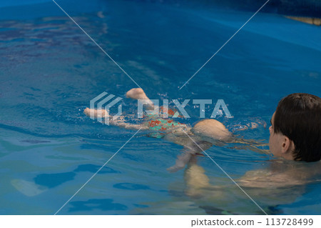 Swim coach teach a baby for diving under water. Swimming lessons for newborns. 113728499