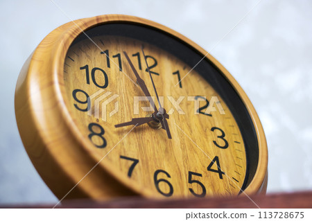 a close up of a wooden clock which shows the time 113728675