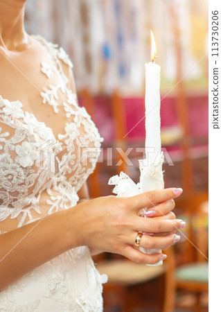 Bride and groom holding the candles. Close up. 113730206