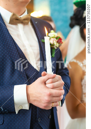 Bride and groom holding the candles. Close up. Bride and groom holding the candles. Close up. 113730207