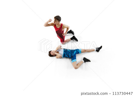 Top view. Two male wrestling athletes in blue and red uniform, showing victory and defeat isolated on white background 113730447