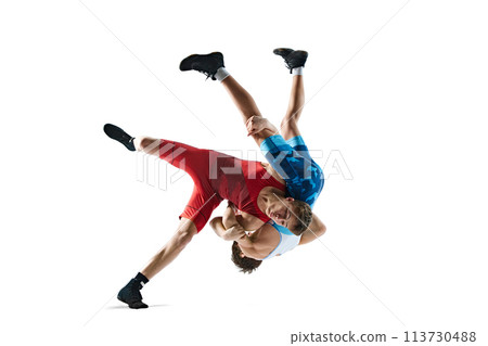 Two greco-roman wrestlers in red and blue uniform wrestling isolated on white background. Competitive young men 113730488