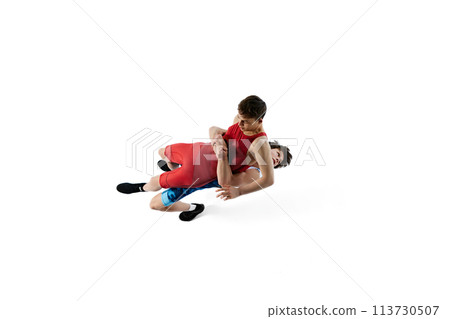 Young men, athletes compete fiercely in wrestling match, displaying determination and skills isolated on white background 113730507