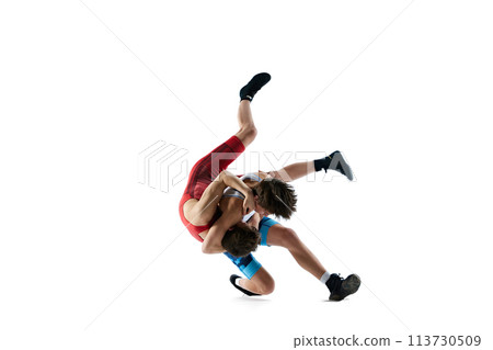 Athletes in motion. Young men in blue and red uniform, wrestlers training, demonstrating strength isolated on white background 113730509