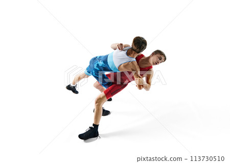 Young male athletes, concentrated wrestlers in motion, competing, demonstrating agility and technique isolated on white background 113730510