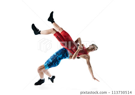 Two male athletes engage in wrestling match, grappling and striving for dominance isolated on white background 113730514