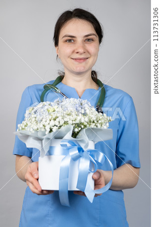 The doctor holds a bouquet of flowers. Happy Doctors Day. 113731306