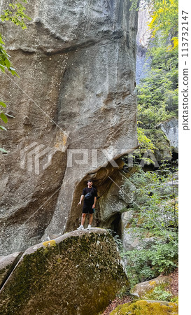 man tourist hiking by rocks on forest man tourist hiking by rocks on forest 113732147