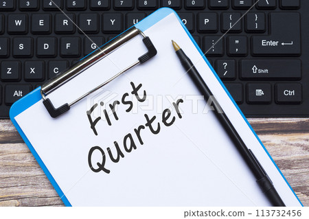 Clipboard with first quoter text with pen and keyboard on wooden desk. 113732456