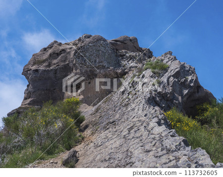 View of rocky top of Pico Grande one of the highest peaks in the Madeira over blue sky. Mountain landscape at hiking trail PR12, Madeira, Portugal 113732605