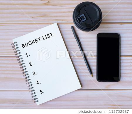 Bucket List word written on notepad on wooden desk. 113732987