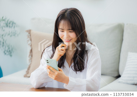 A woman watching a smartphone 113733034