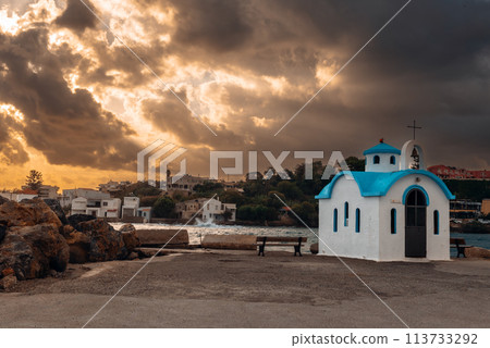 Beautiful chapel on the coast on Crete on rays of sunrise. Beautiful chapel on the coast on Crete on rays of sunrise. 113733292