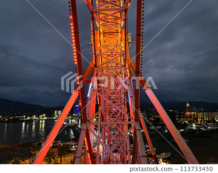 Ferris wheel in amusement park, large metal structure on night city and sky cloud Ferris wheel in amusement park, large metal structure on night city and sky cloud 113733450