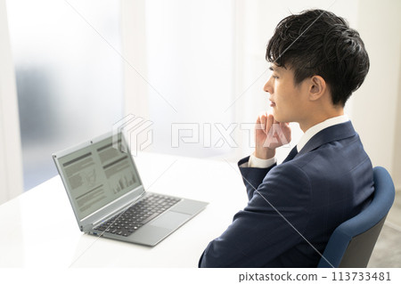 一位男性商人在筆記型電腦上創建文件時感到擔憂 113733481