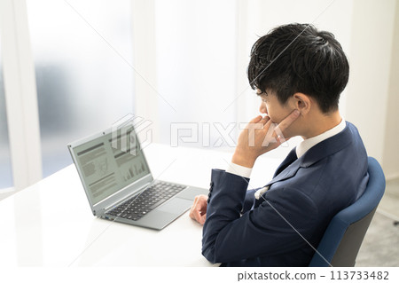 一位男性商人在筆記型電腦上創建文件時感到擔憂 113733482