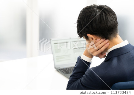 A male businessman having trouble creating documents on a laptop 113733484