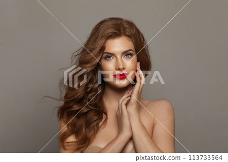 Gorgeous fashionable redhead woman with long wavy hair and make-up. Studio headshot portrait  113733564