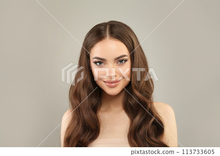 Gorgeous young female model with healthy hair, makeup and shiny clear skin posing  113733605