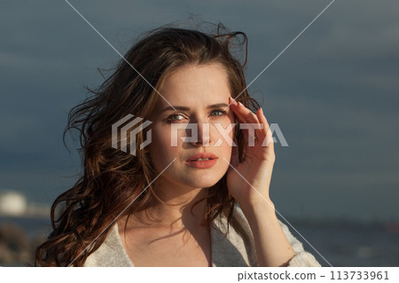 Thoughtful brunette woman with fresh skin, natural make-up and healthy wavy brown hair  113733961