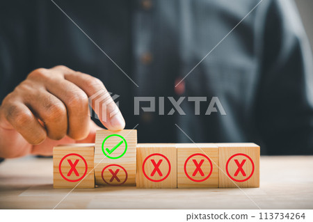 Wooden cube flipped by hand, red cross to correct tick representing project approval concept. Close-up symbolizing choice. Think With Yes Or No Choice. Wooden cube flipped by hand, red cross to correct tick representing project approval concept. Close-up symbolizing choice. Think With Yes Or No Choice. 113734264