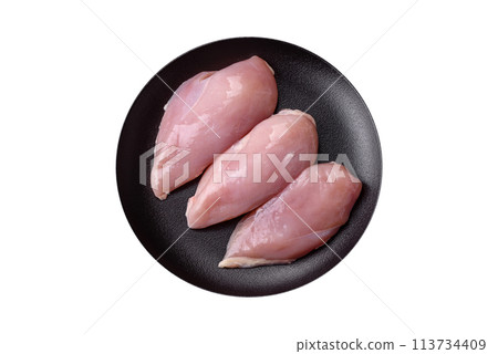 Fresh chicken fillet on a dark concrete table with spices and herbs Fresh chicken fillet on a dark concrete table with spices and herbs 113734409