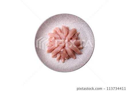 Slices of raw chicken or turkey fillet with salt, spices and herbs Slices of raw chicken or turkey fillet with salt, spices and herbs 113734411