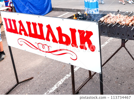 Cooking barbecue in the grill on the street. Inscription on russian 113734467