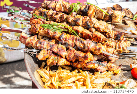 Shashlik during of cooking on the mangal over hot charcoals outdoors, street food 113734470