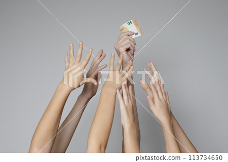 Human hand holding euro banknote cash money on a gray background 113734650
