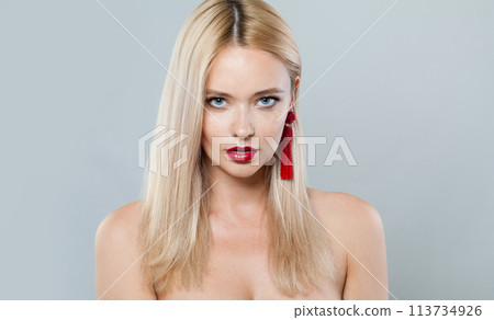 Beauty fashion model woman with blonde hair wears big red color earrings. Fashionable lady Beauty fashion model woman with blonde hair wears big red color earrings. Fashionable lady 113734926