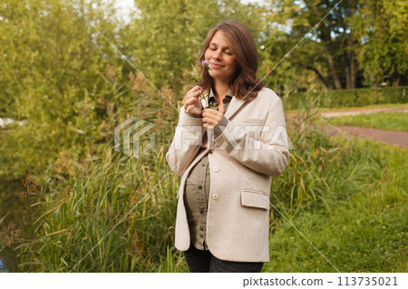 Young cute pregnant woman resting outdoors 113735021