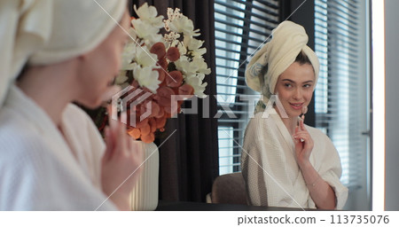 Young woman using jade facial roller for face massage in her bedroom. Beauty skin care. 113735076