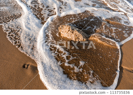 Directly above view of waves breaking on shore at sunset. Directly above view of waves breaking on shore at sunset. 113735836