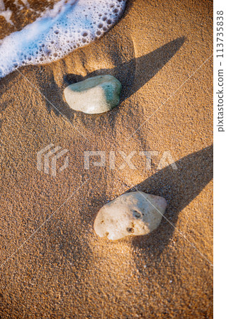 sea sand and stones, waves on the beach at sunset sea sand and stones, waves on the beach at sunset 113735838