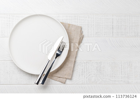 Empty plate on wooden table, overhead view 113736124